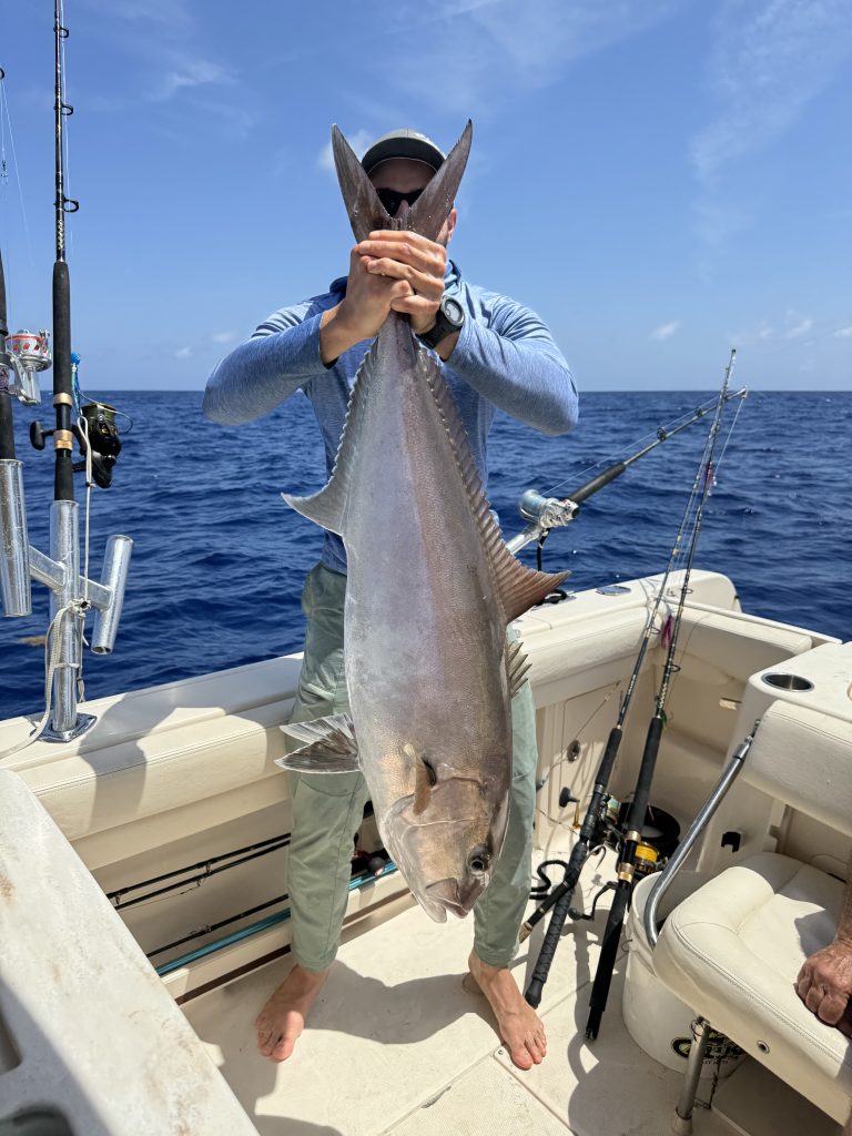 Angler holding a freshly caught fish on a Blue Skies fishing charter